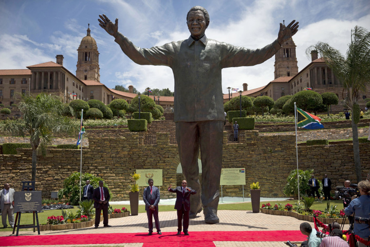 Image: South Africa President Jacob Zuma, center, gestures as he speaks after the unveiling of a bronze statue of former South Africa President Nelson Mandela outside Union Buildings in Pretoria, South Africa, on Dec. 16as part of the Day of Reconciliatio