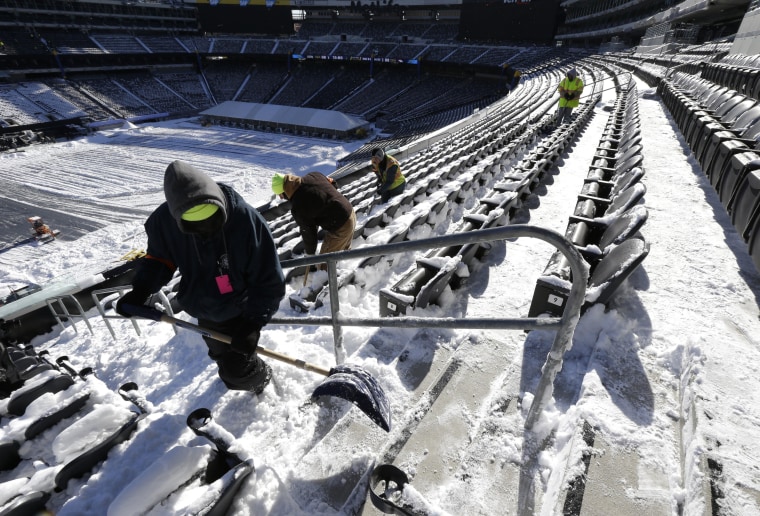 Image: Workers shovel snow off seating area at MetLife Stadium