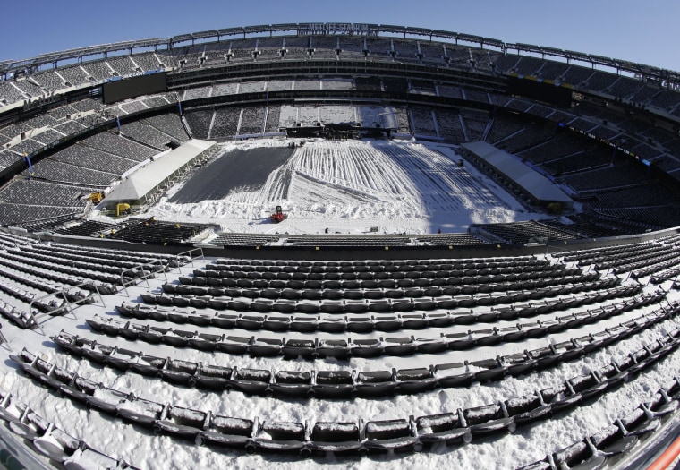 In this photograph taken with a fisheye lens, snow is accumulated on the seats and on the field of MetLife Stadium as crews removed snow ahead of Super Bowl XLVIII following a snow storm, Wednesday, Jan. 22, 2014, in East Rutherford, N.J. Super Bowl XLVIII, which will be played between the Denver Broncos and the Seattle Seahawks on Feb. 2, will be the first NFL title game held outdoors in a city where it snows. (AP Photo/Julio Cortez)