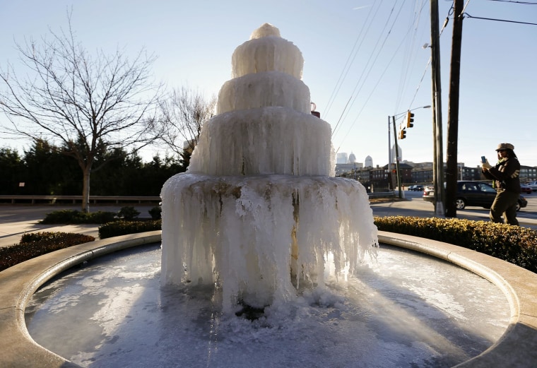 Image: A woman walks past a frozen fountain in Atlanta on Friday.