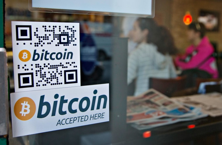 Signs on window advertise a bitcoin ATM machine that has been installed in a Waves Coffee House in Vancouver, British Columbia in this October 28, 2013 file photo.