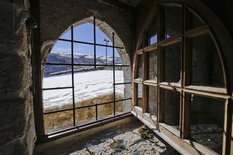 Image: A broken window is seen in the small mountain church of San Pietro della Ienca, near the city of L'Aquila