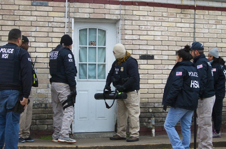 Federal agents prepare to enter a business during a raid, Thursday, Jan. 30, 2014, in southwest Houston. The raid was part of a crackdown on an alleged human smuggling ring operating in Texas and other states.