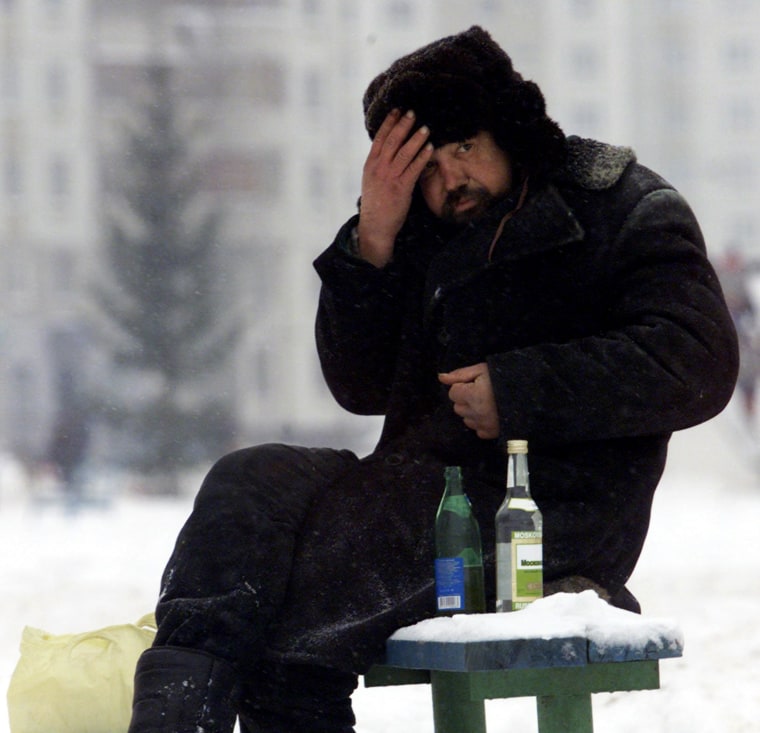A homeless man warms himself up with a mixture of vodka and beer in a Moscow