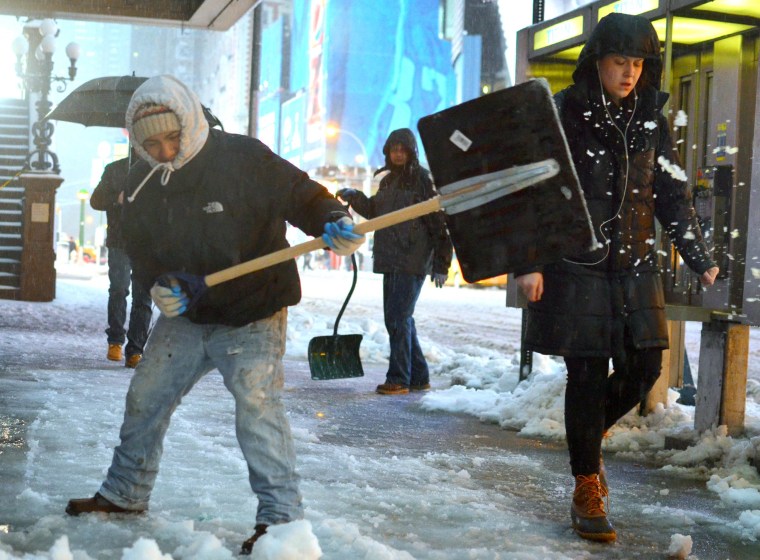 A worker attempts to keep the sidewalks clear near Times Square in New York City as the Northeast continues to get hit with a wintry mix on Wednesday.