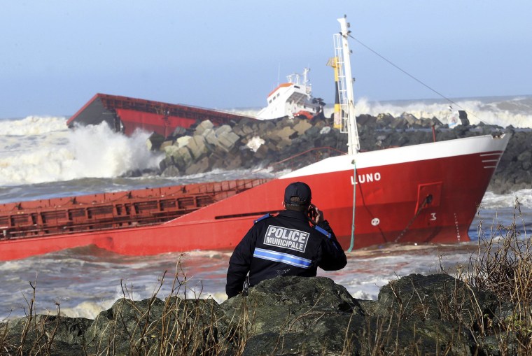 Image: A police officer watches a Spanish cargo ship that slammed into a jetty