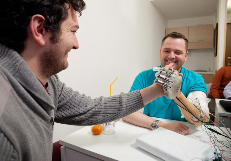 Dennis Sorensen of Aarborg, Denmark tries out a new prosthetic hand that lets him feel the objects he is handling.