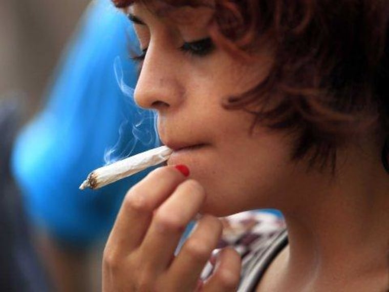 A young woman using a marijuana cigarette