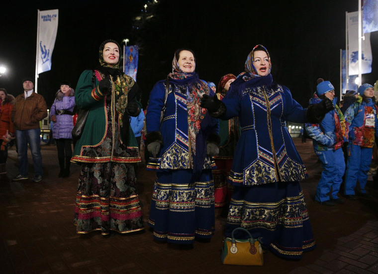 Three women in traditional Russian costumes dance as they watch the live broadcast of the opening ceremony of the 2014 Winter Olympics on Feb. 7 in Krasnaya Polyana, Russia.