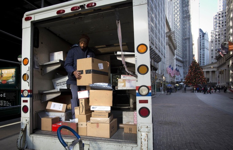A U.S. Postal Service employee prepares to deliver packages on Christmas Eve at Wall Street in New York