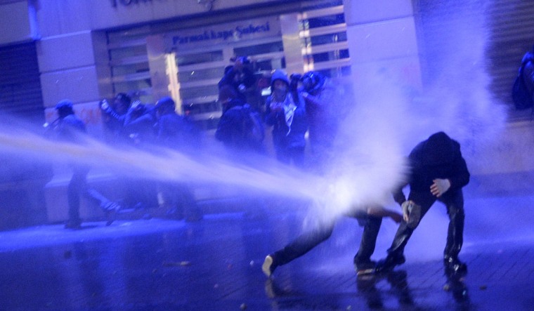 Image: Protesters are hit by water cannons