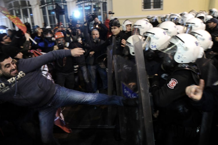 Image: A protester clashes with riot police