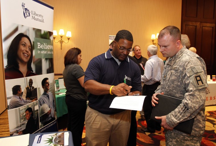 Army Major George Weilhamer, of Greenwood, Ind., talks with a recruiter from Liberty Mutual at a job fair in Indianapolis, Wednesday, March 23, 2011. Weilhamer is retiring from the Army in April. Fewer people applied for unemployment benefits last week, evidence that layoffs are slowing and employers may be stepping up hiring.(AP Photo/Michael Conroy)