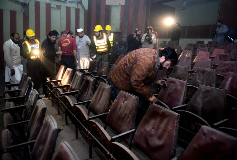 Image: Pakistani volunteers search a cinema hall after a grenade attack