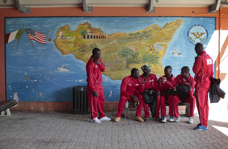 Image: African migrants, who are members of the ASD Mineo soccer team, talk as they wait to go to their Sunday match, in the immigration centre near the Sicilian village of Mineo