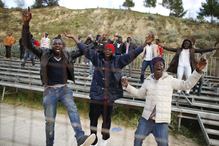Image: African migrants, who are supporters of the ASD Mineo soccer team, celebrate after a goal in the Sicilian village of Mineo
