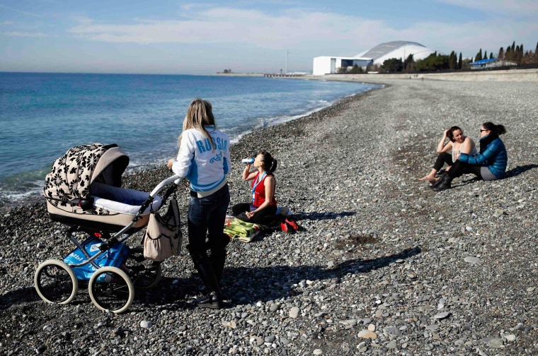 Image: Local residents enjoy nice weather on the beach at the Black Sea near the Olympic Park during the 2014 Sochi Winter Olympics