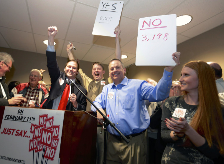 State Sen. Charlie Janssen of Fremont, third left, Jeremy Jensen, center, and John Wiegert, second right, celebrate in Fremont, Neb., Tuesday, Feb. 11, 2014, after city voters have decided by voting no, to uphold the law designed to bar immigrants from renting homes if they don’t have legal permission to be in the U.S. 