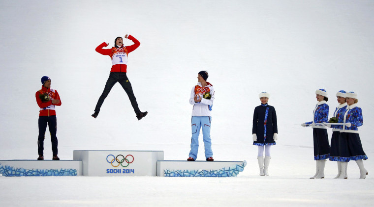 Image: Winner Germany's Frenzel jumps on the podium during the flower ceremony for the Nordic combined individual normal hill 10 km event at the Sochi 2014 Winter Olympic Games
