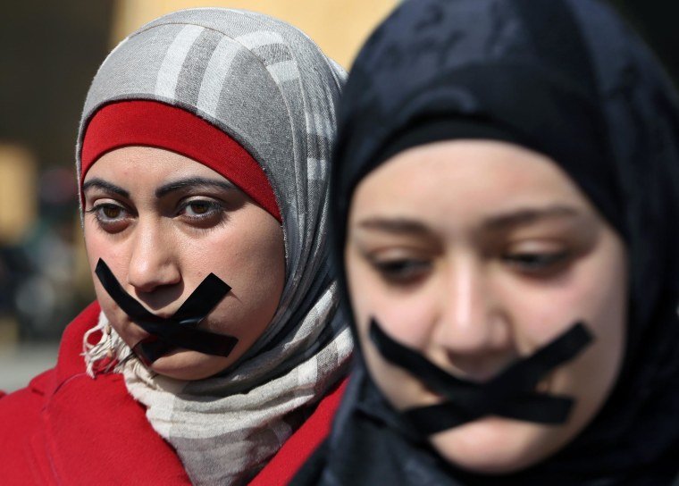 Image: Lebanese journalists and activists use tape to cover their mouths to show their solidarity with detained journalists in Egypt