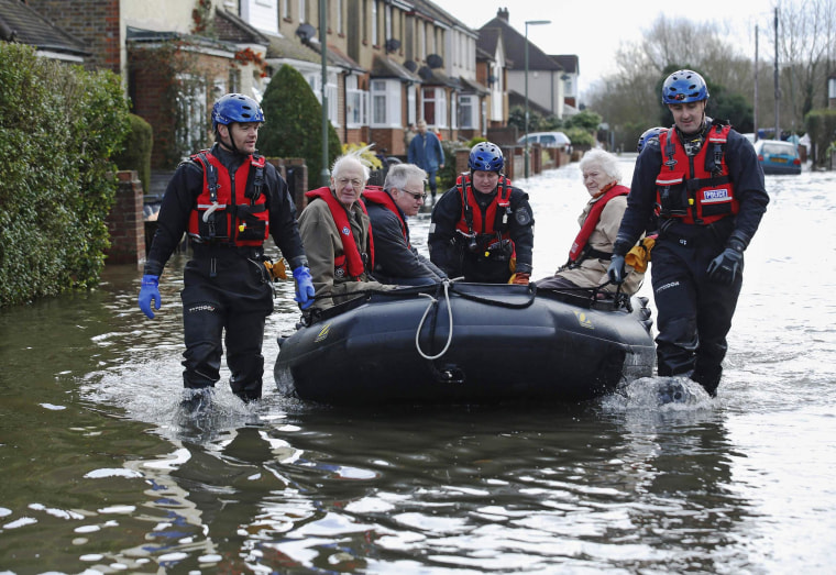 Image: Police specialist search team rescues Archie and Dorothy Doye  from their home which was surrounded by flood water at Egham after the River Thames burst its banks in south east England