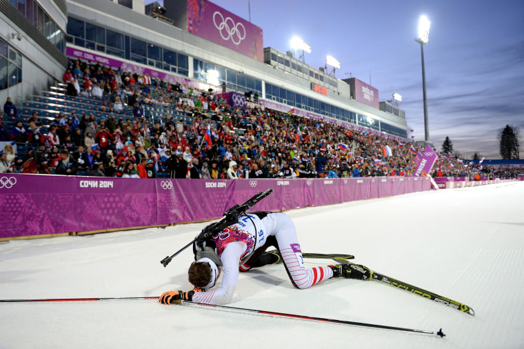 Image: Simon Eder of Austria collapses in the snow after the Men's Individual 20 km during day six of the Sochi 2014 Winter Olympics