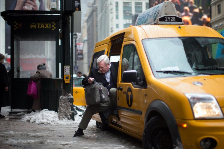 Image: A passenger struggles to exit his taxi over a slush puddle
