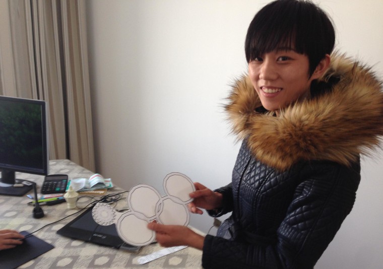 Yan Wenjuan helps her partner Zhang Zhen to print T-shirts that cash in on the Sochi Olympic rings glitch.