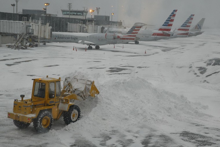 Bulldozer clears the gate areas of snow at LaGuardia Airport, New York. Another 1,600 flights were canceled on Friday on the East Coast.