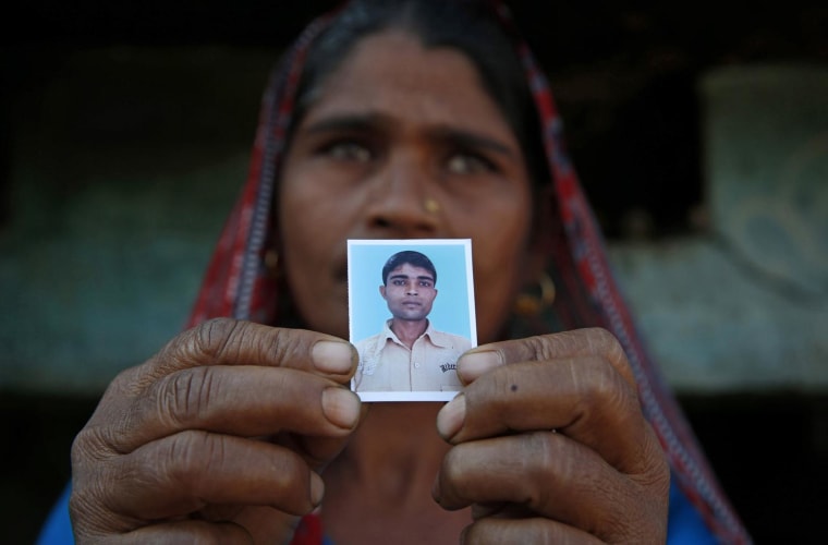 Image: Taravati, who uses only one name, shows a photograph Wednesday of her son Shiv Kumar Singh, a daily wage laborer, who was killed by a tiger at Maniawala, in northern India.