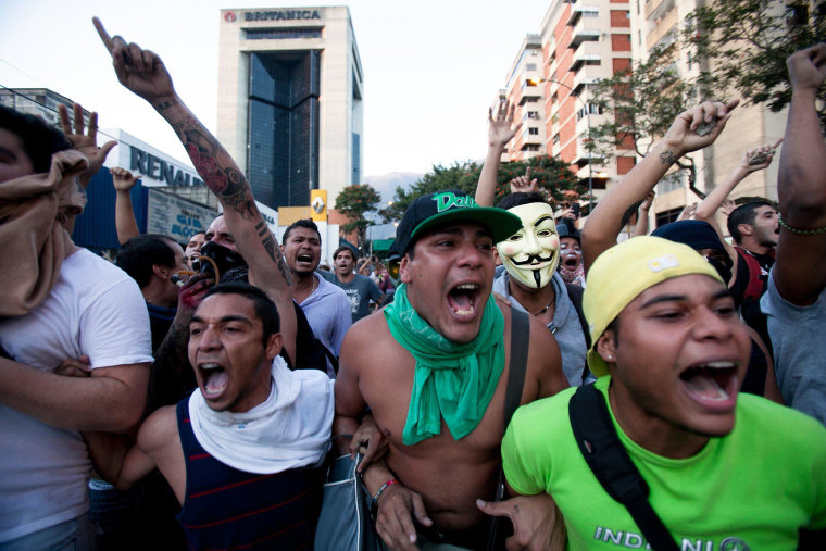 Image: Opposition demonstrators shout slogans against the National Bolivarian Police