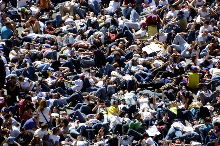 Image: Thousand of anti-government students lie on the ground during a protest in Caracas