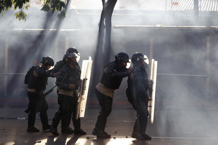 Image: Riot police is seen among tear gas as they fight against students during a protest against Nicolas Maduro's government in Caracas