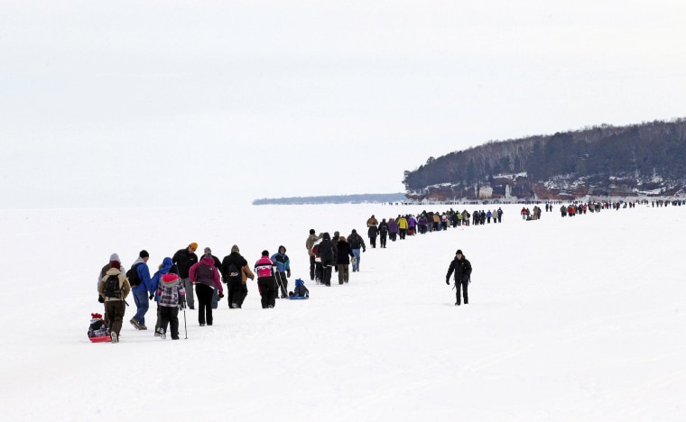 Image: Sightseers trek across a frozen expanse of Lake Superior to the sea caves of the Apostle Islands National Lakeshore