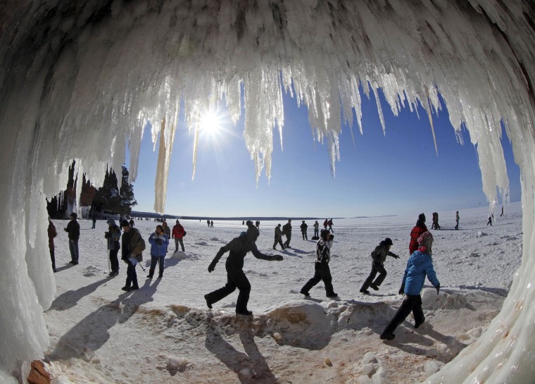Image: Sightseers look at icicles in sea caves of the Apostle Islands National Lakeshore of Lake Superior