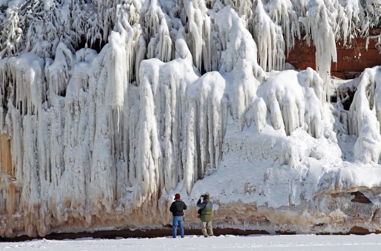 Image: Sightseers look at a frozen rock face along the Apostle Islands National Lakeshore of Lake Superior