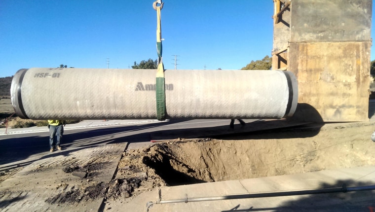 Workers install pipe during construction of a desalination plant in Carlsbad, Calif.