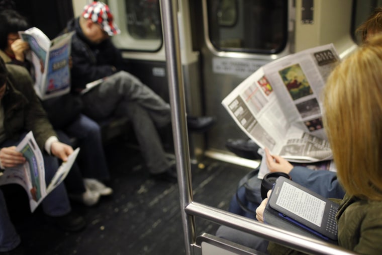 Image: A commuter reads on her Kindle e-reader while riding the subway in Cambridge, Mass.