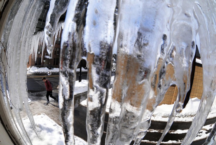 Image: A pedestrian passes near a cluster of slowly melting icicle's in downtown Scranton, Pa.