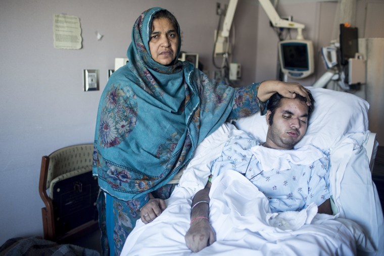 Tanzeela Bajwa stands by the side of her son, Muhammad, who lies comatose in a hospital bed at St. Mary's Medical Center in Duluth, Minn.