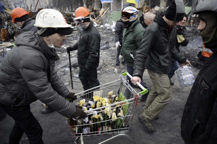 Image: Anti-government protesters carry petrol bombs in a trolley during clashes with riot police in Independence Square in Kiev