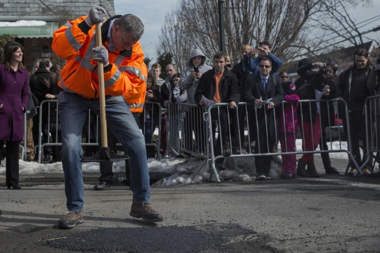 New York Mayor Bill de Blasio finishes filling a pothole in the Maspeth section of Queens.