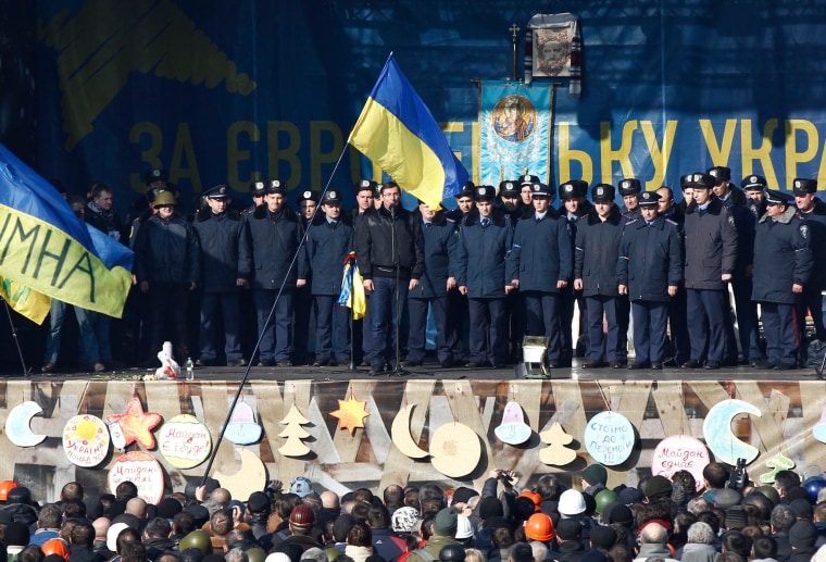 Image: Police officers from Lviv who joined anti-government protesters appear on a stage in Kiev's Independence Square