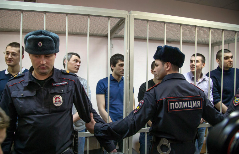 Image: Defendants stand in a glass cage during a trial in Zamoskvoretsky District Court in Moscow