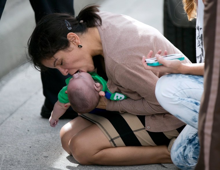 Image: Pamela Rauseo, 37, performs CPR on her nephew, five-month-old Sebastian de la Cruz