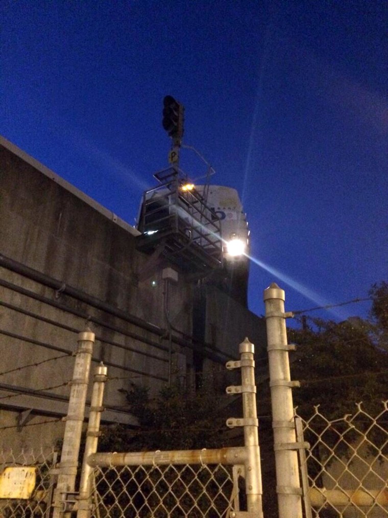 Image: BART train hangs over the edge of the elevated rail.