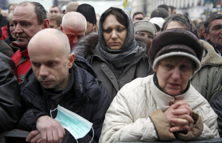 Image: People pray during a funeral service for two anti-governent protesters who were killed after days of violence in Kiev