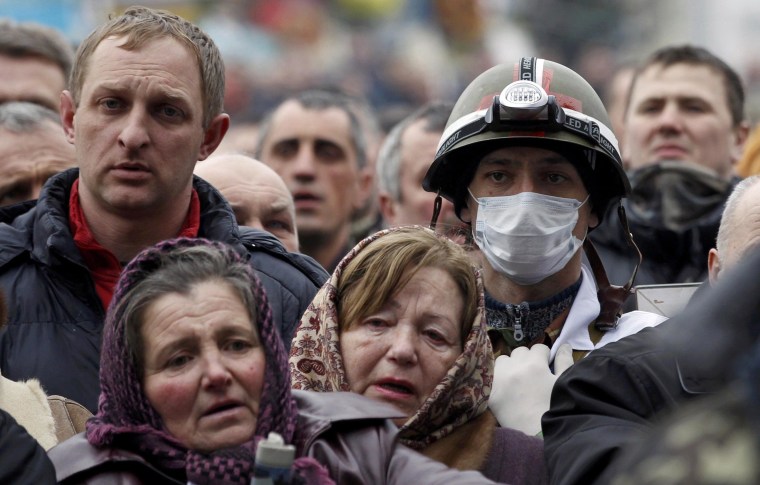 Image: People pray during a funeral service for two anti-governent protesters who were killed after days of violence in Kiev