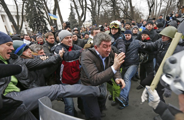 Anti-government protesters attack a deputy of the Party of Regions, Vitaly Grushevsky, outside the Ukrainian Parliament building in Kiev on Saturday. Downtown Kiev looked to be in the hands of the opposition on Saturday, after President Viktor Yanukovych made huge concessions to protesters and then left the city.
