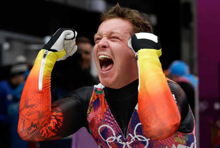 Image: Felix Loch of Germany celebrates after he crossed the finish area to win the gold medal during the men's singles luge final
